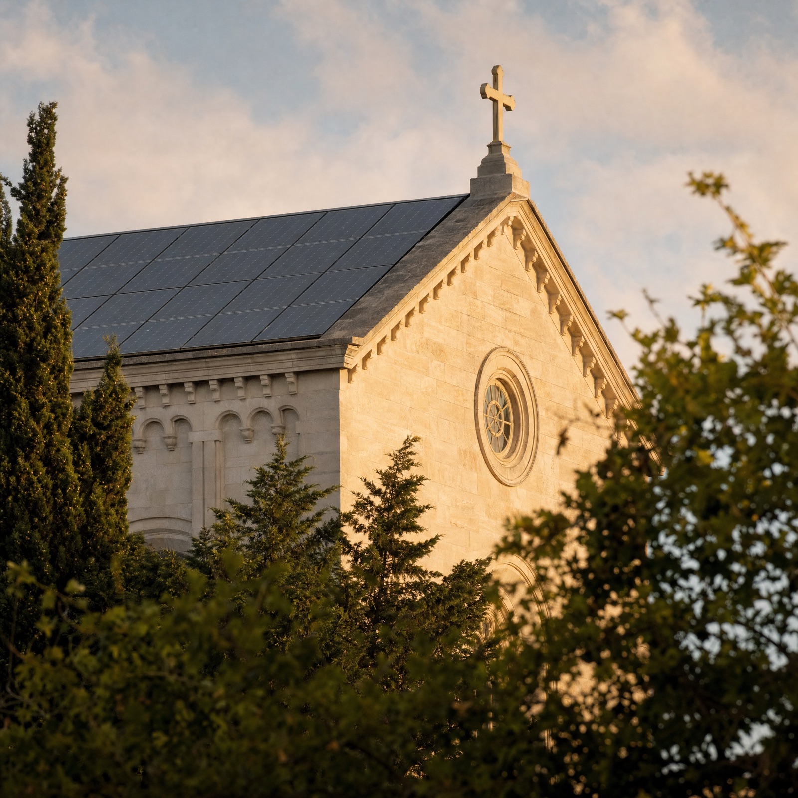 A stone church with rooftop solar in warm golden light